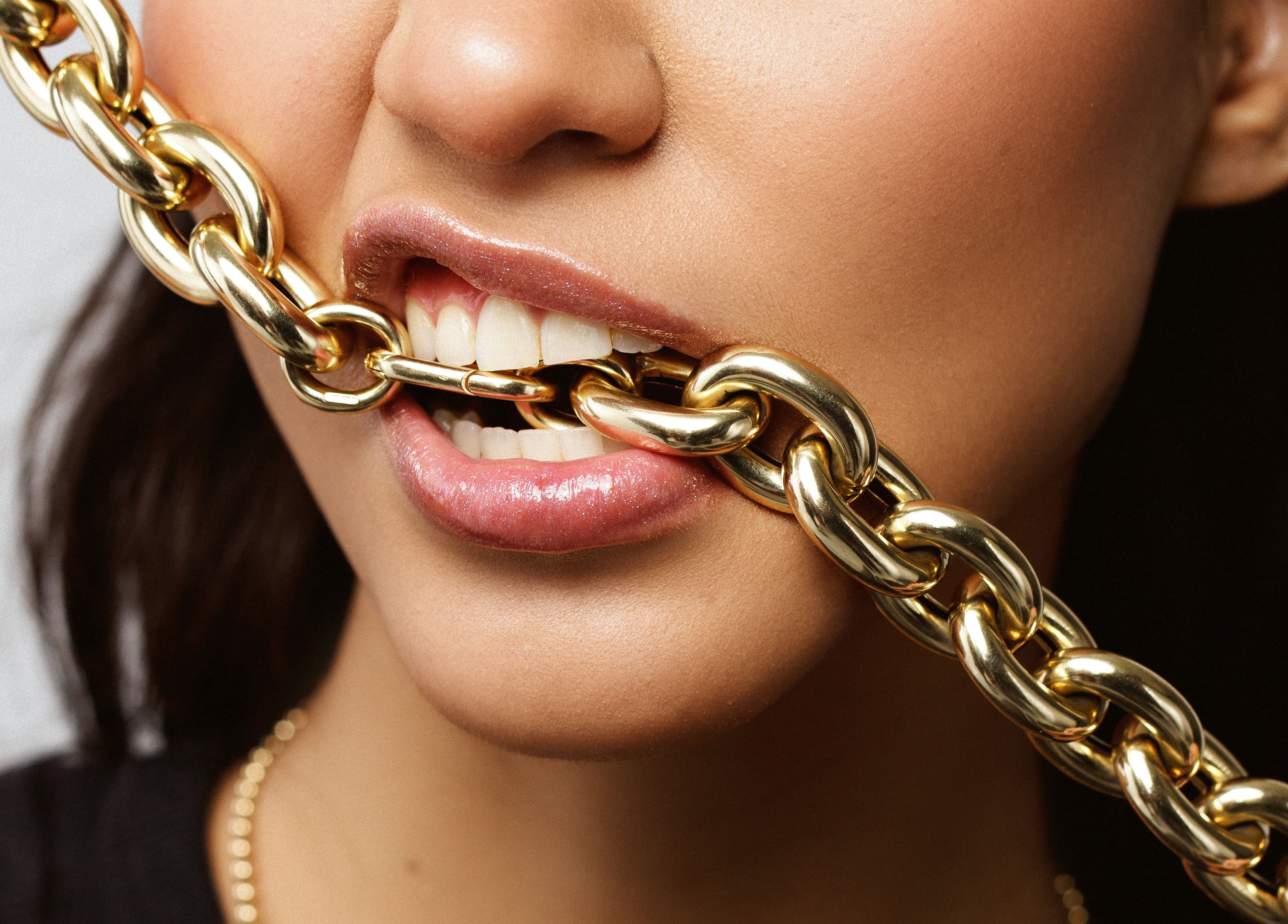 bold gold big link chain necklace shown in model's mouth