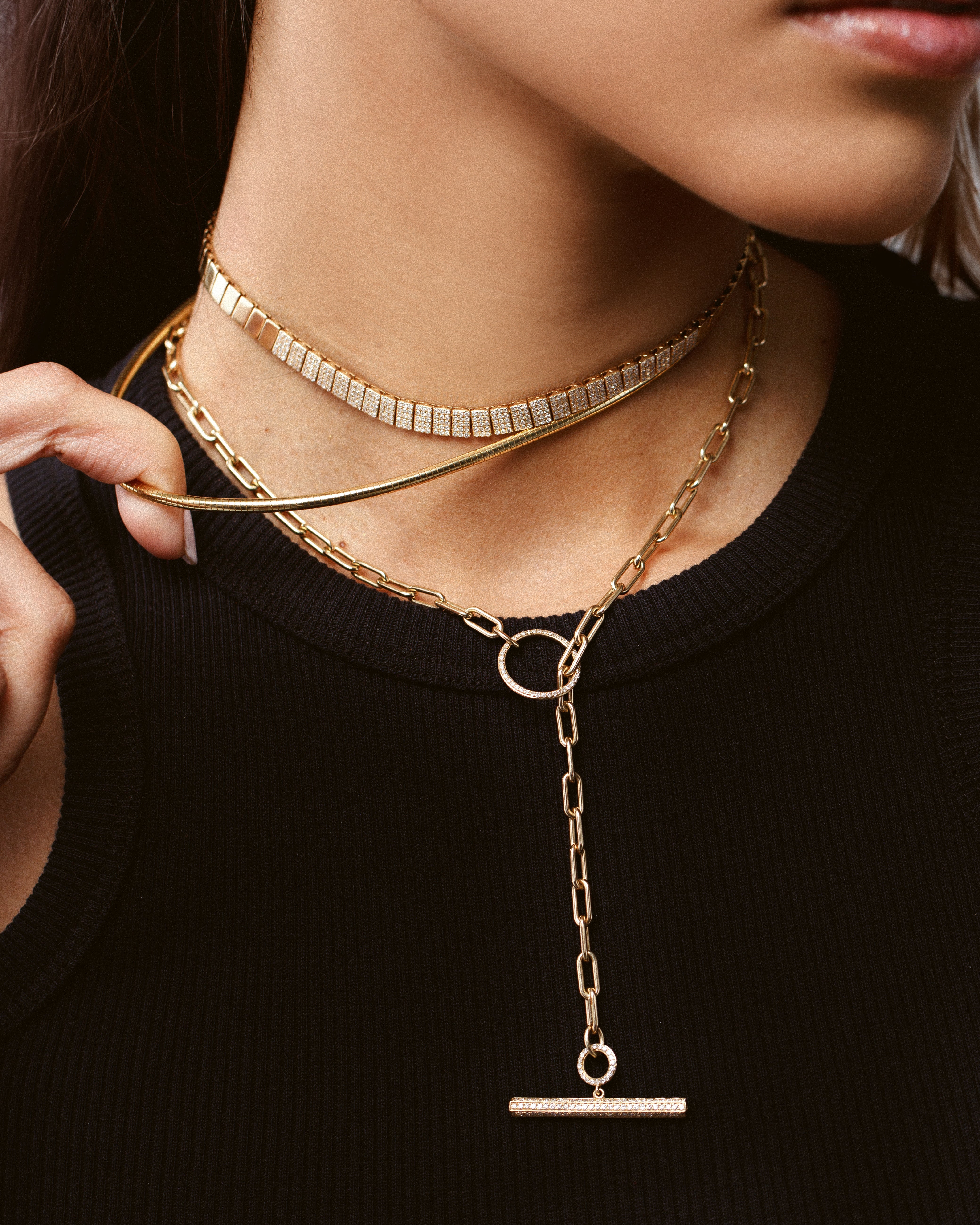 gold and diamond choker work with gold necklaces on model with black shirt