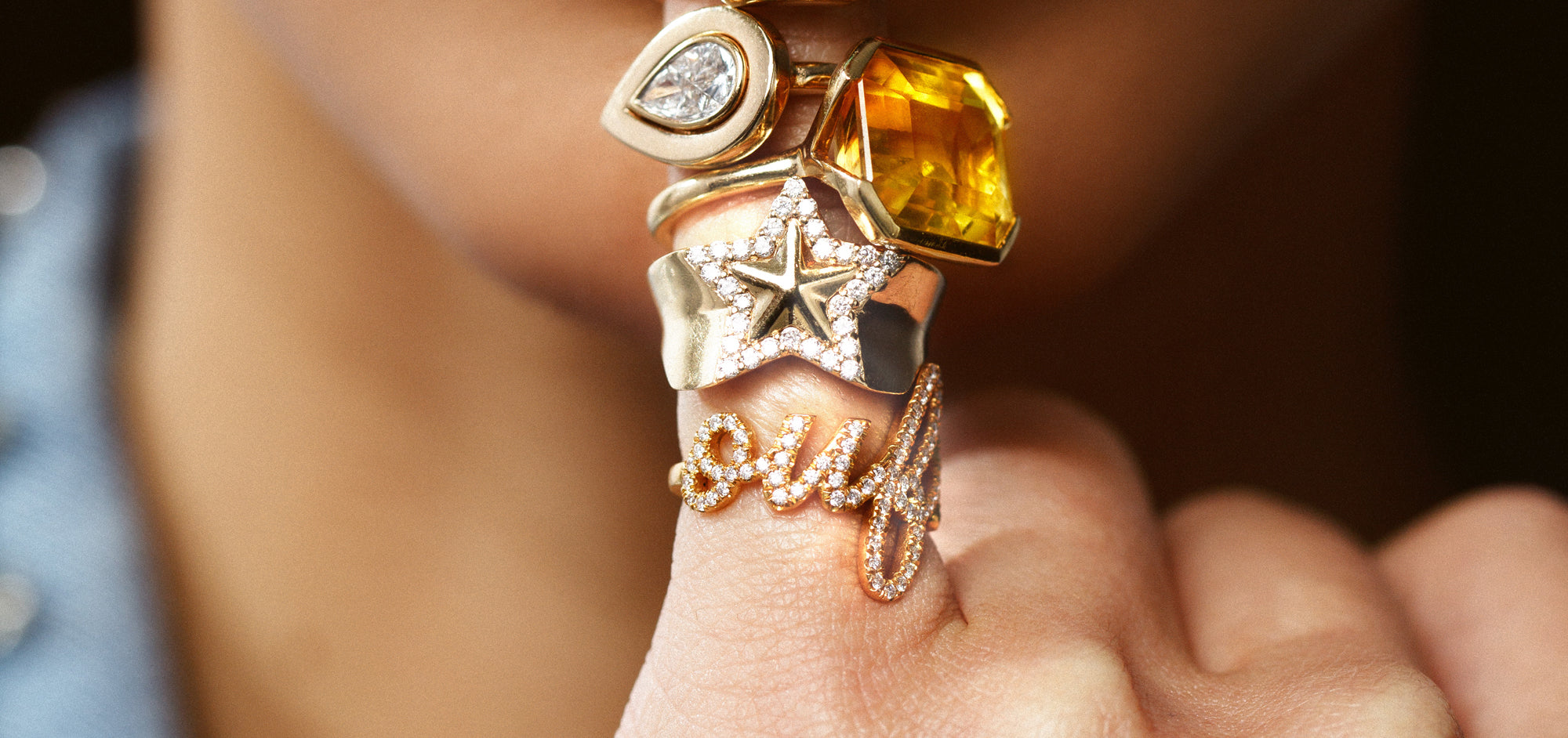 gold and diamond and gemstone rings stacked on finger